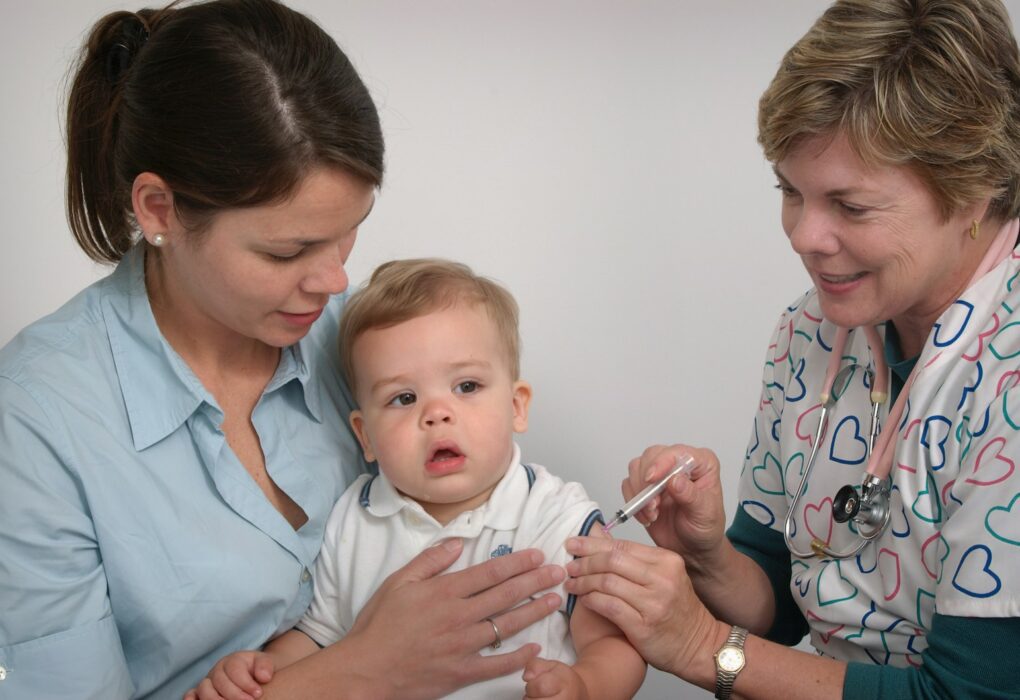a baby being examined by a doctor and nurse