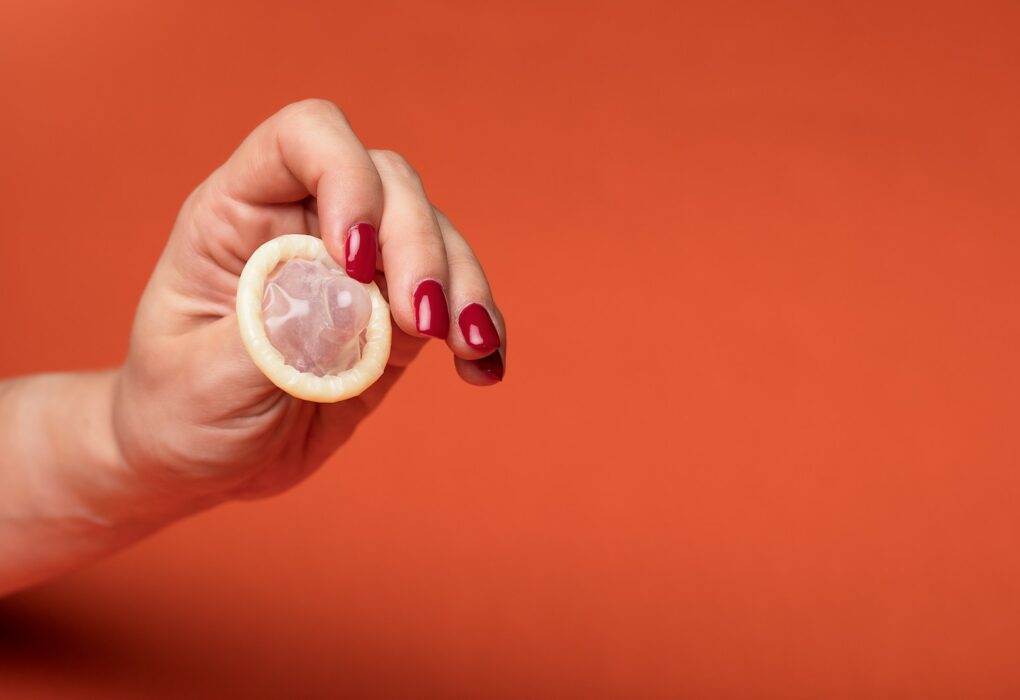 person holding clear drinking glass with yellow liquid