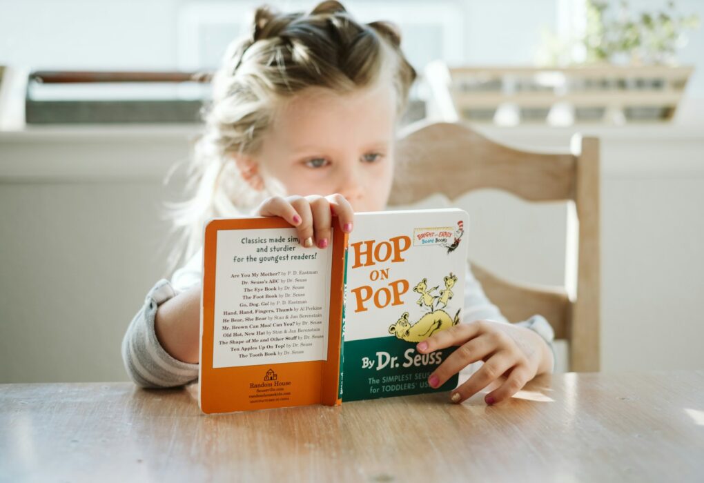 girl sitting while reading book
